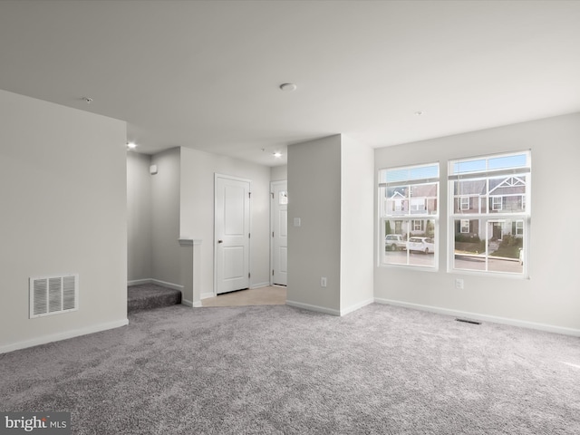 carpeted empty room with baseboards and visible vents