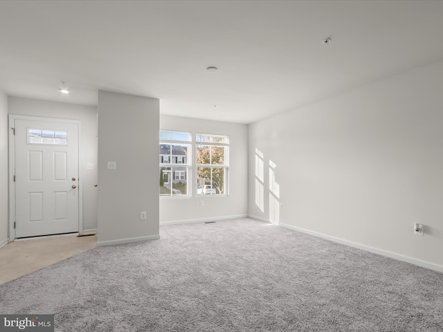 interior space with baseboards and light carpet