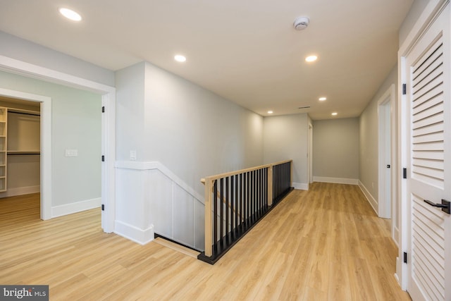 hall featuring recessed lighting, an upstairs landing, and light wood finished floors