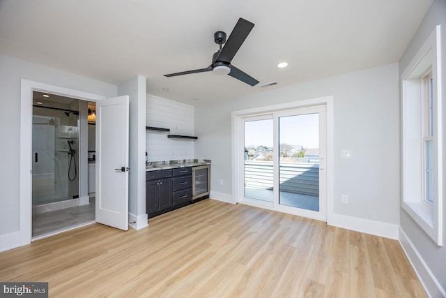 unfurnished living room with ceiling fan, beverage cooler, recessed lighting, light wood-type flooring, and visible vents