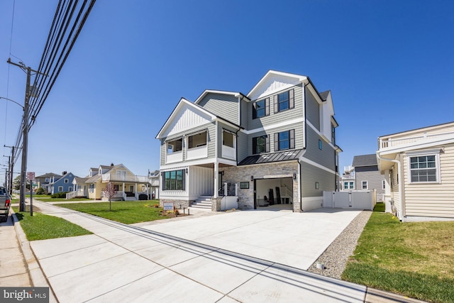 view of front of home with a residential view, stone siding, a garage, board and batten siding, and driveway