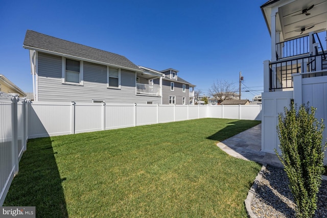 view of yard with a fenced backyard and a balcony
