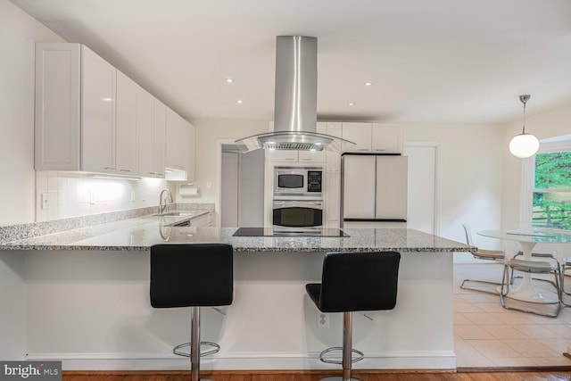 12405 Ellen Ct, Silver Spring, MD 20904 - kitchen featuring island range hood, built in appliances, a sink, a peninsula, and light stone countertops