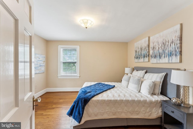 bedroom with wood finished floors and baseboards