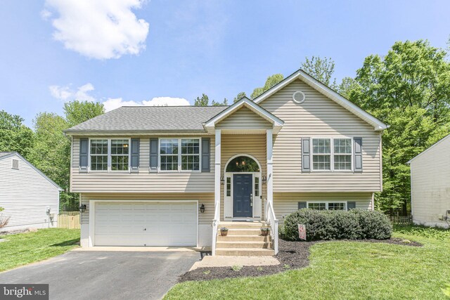 split foyer home with an attached garage, aphalt driveway, and a front yard