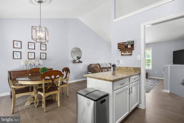 kitchen with pendant lighting, dark wood-style flooring, a chandelier, and vaulted ceiling