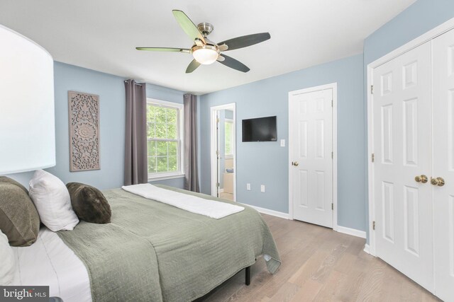 bedroom featuring baseboards, ceiling fan, wood finished floors, and connected bathroom