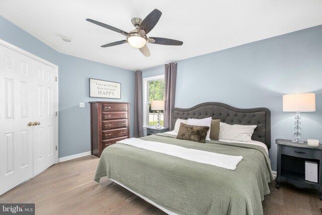 bedroom featuring a ceiling fan, baseboards, and wood finished floors