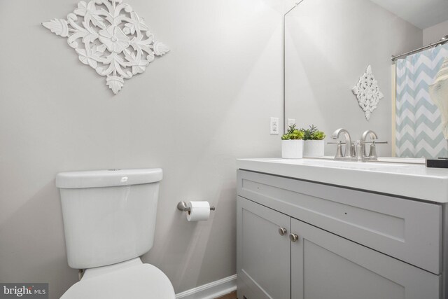 full bathroom with toilet, baseboards, and vanity