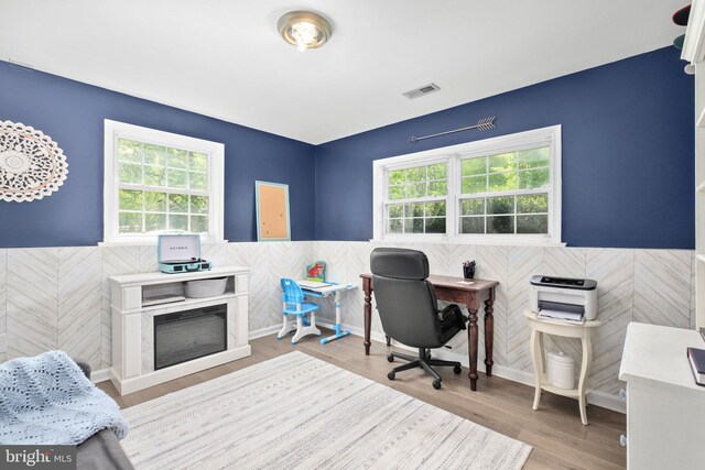 office area with visible vents, wood finished floors, a wainscoted wall, and tile walls