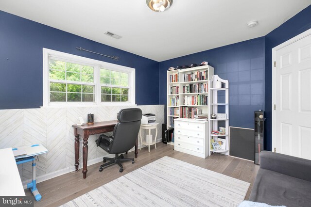 office area with visible vents, baseboards, and wood finished floors