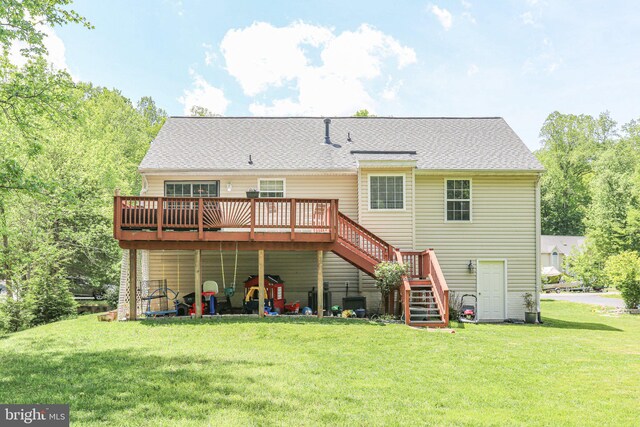 rear view of house with roof with shingles, a wooden deck, a yard, and stairway