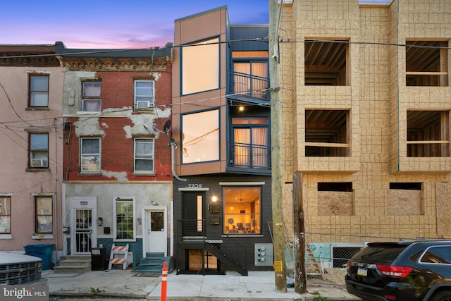 property at dusk with cooling unit and entry steps