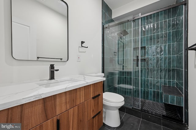 bathroom with vanity, toilet, tile patterned floors, and a stall shower