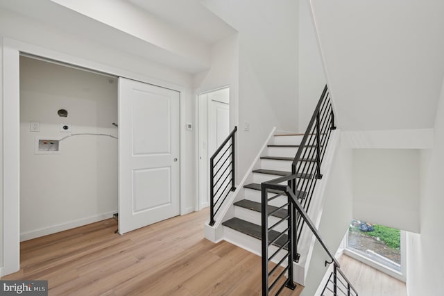 staircase with baseboards and wood finished floors