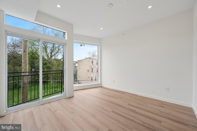 spare room featuring recessed lighting, baseboards, and light wood-type flooring
