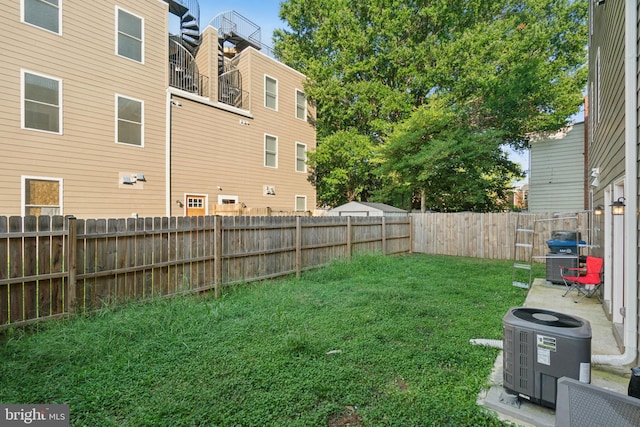 view of yard with central AC unit and a fenced backyard