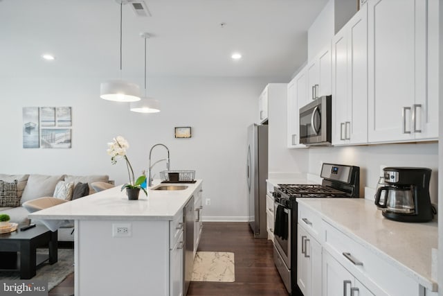 kitchen featuring white cabinets, dark wood-style flooring, a sink, a kitchen island with sink, and stainless steel appliances