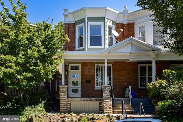 view of front of home featuring covered porch and brick siding