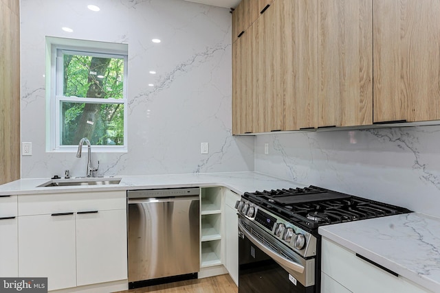 kitchen featuring a sink, appliances with stainless steel finishes, modern cabinets, and decorative backsplash