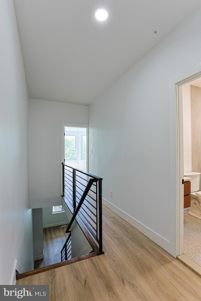 staircase with baseboards and wood finished floors