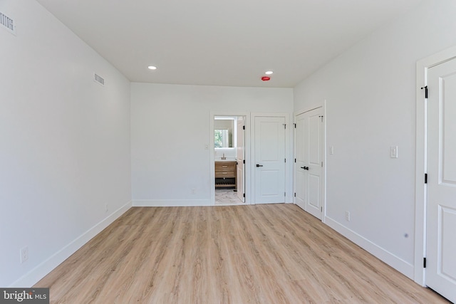 unfurnished bedroom featuring baseboards, recessed lighting, light wood-style flooring, and visible vents