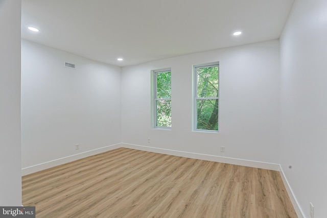 empty room with baseboards, recessed lighting, light wood-style flooring, and visible vents