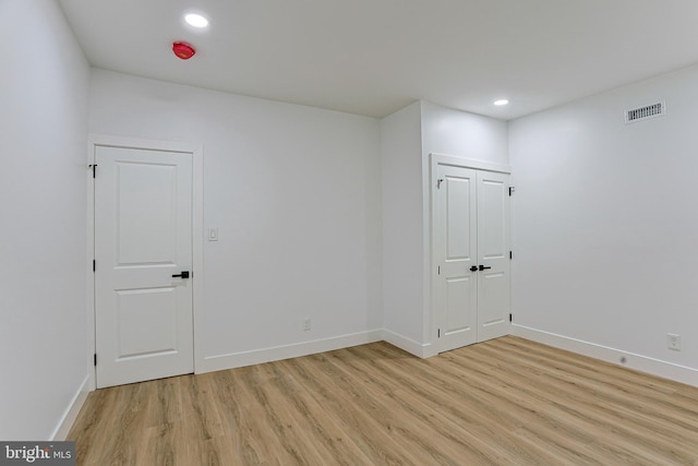 empty room with baseboards, recessed lighting, light wood finished floors, and visible vents
