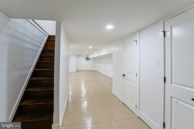hall featuring recessed lighting, baseboards, stairway, and finished concrete flooring