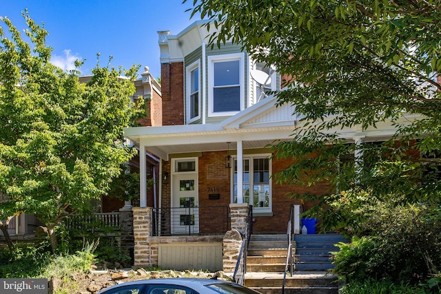 view of front of home featuring brick siding and covered porch