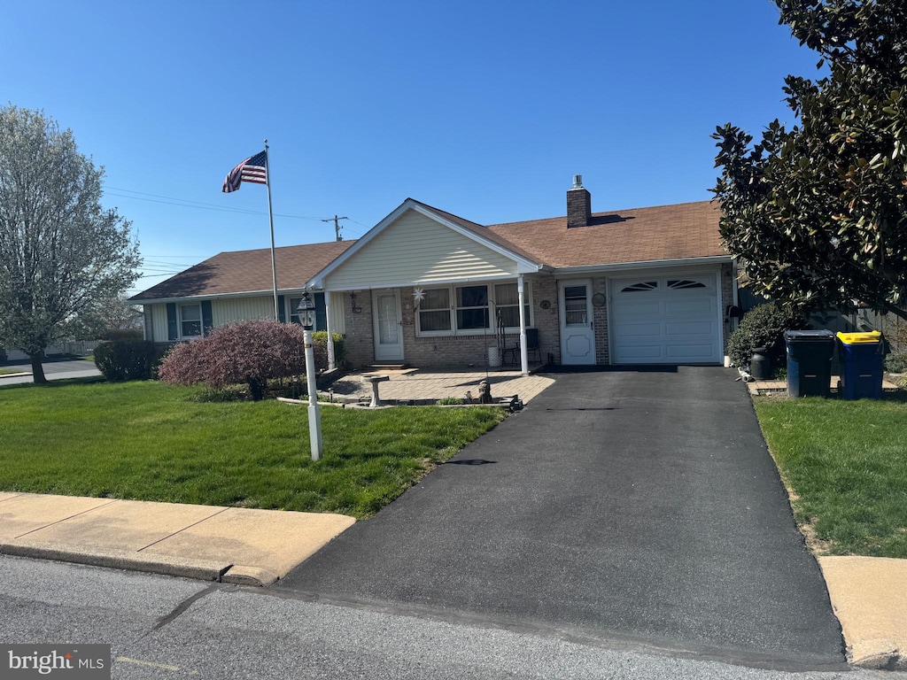 345 W Cedar St, New Holland, PA 17557 - ranch-style house featuring an attached garage, a front lawn, brick siding, a chimney, and driveway