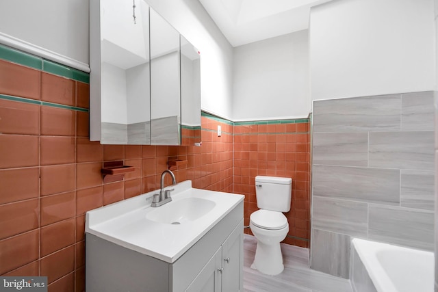 bathroom featuring toilet, a washtub, tile walls, and vanity