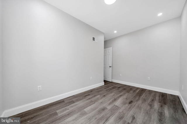 spare room with baseboards, recessed lighting, wood finished floors, and visible vents