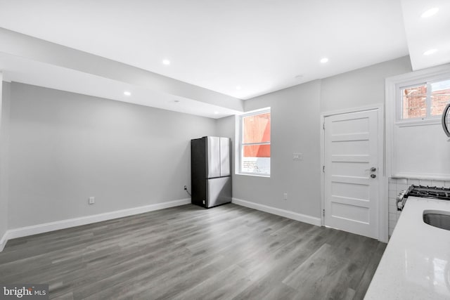 kitchen with recessed lighting, freestanding refrigerator, baseboards, and wood finished floors