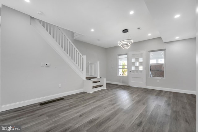 foyer entrance with stairs, visible vents, and dark wood-style floors