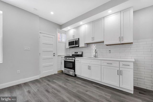 kitchen with light countertops, recessed lighting, appliances with stainless steel finishes, and wood finished floors