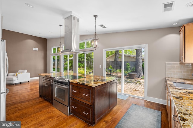 kitchen featuring visible vents, baseboards, appliances with stainless steel finishes, and island exhaust hood