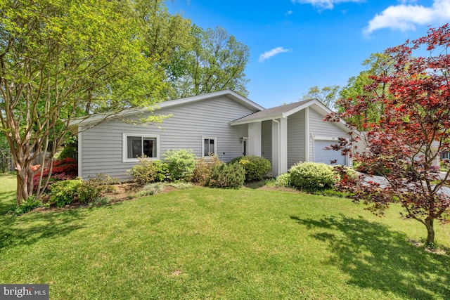 view of side of property featuring a garage and a yard