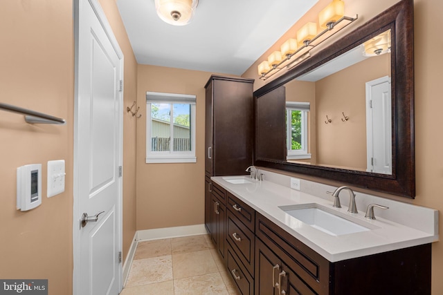 full bath featuring a sink, baseboards, and double vanity