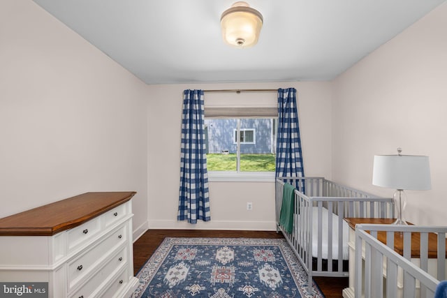 bedroom with baseboards and dark wood-type flooring