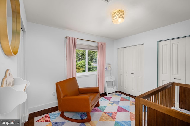 bedroom featuring baseboards, multiple closets, and wood finished floors