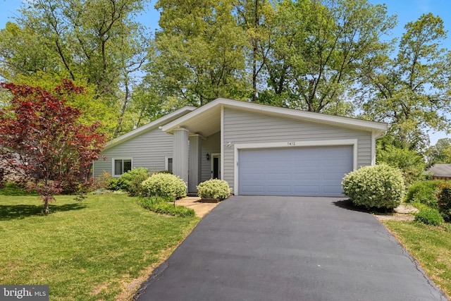 view of front of house with a garage, driveway, and a front lawn