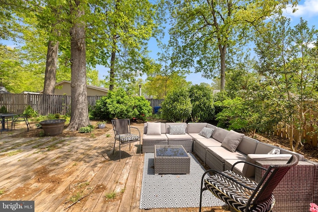 deck with an outdoor living space and a fenced backyard