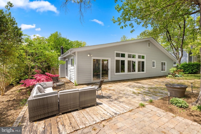 rear view of property with a deck and an outdoor hangout area