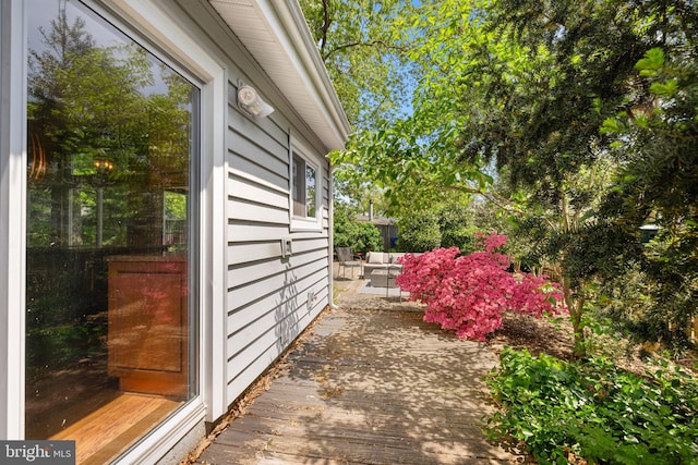 view of property exterior with an outdoor hangout area and a wooden deck