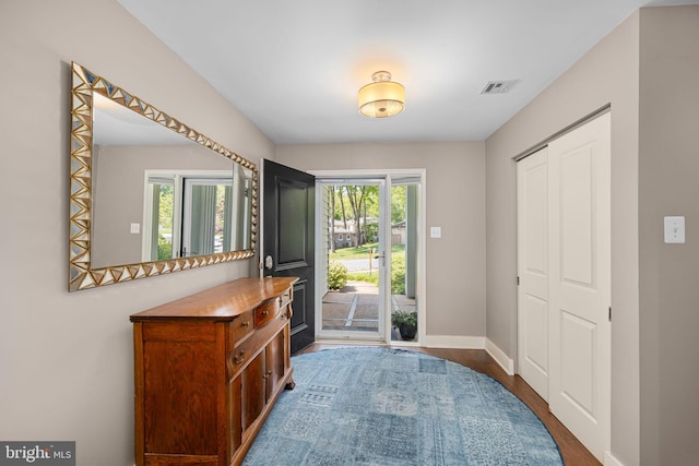 foyer featuring dark wood-style flooring, baseboards, and visible vents