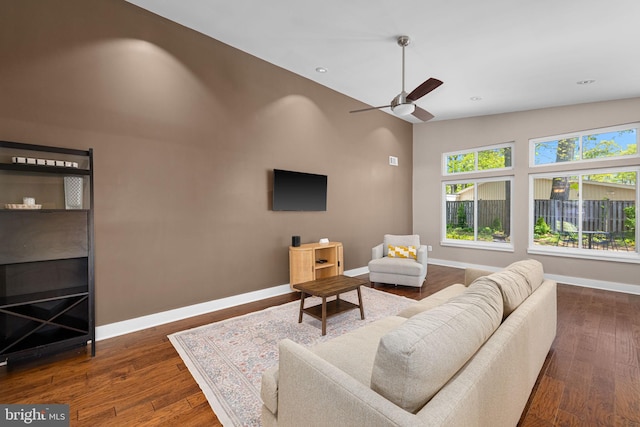 living room with a ceiling fan, dark wood-style flooring, a towering ceiling, baseboards, and recessed lighting