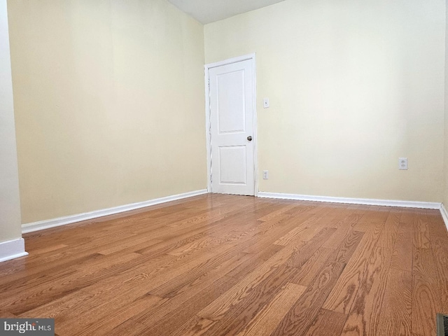empty room featuring baseboards, light wood-type flooring, and visible vents