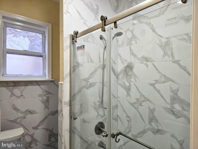 full bath featuring a stall shower and toilet