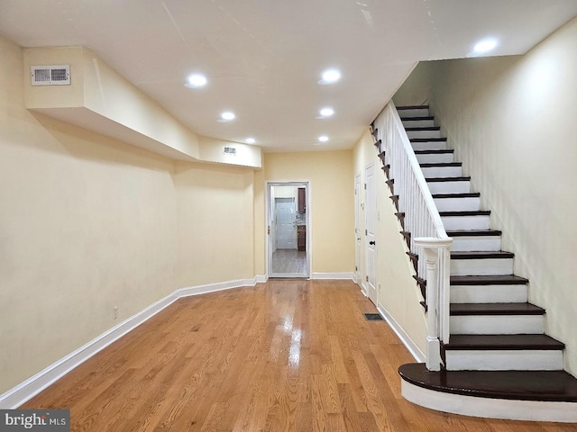 basement with stairs, recessed lighting, visible vents, and light wood-style floors